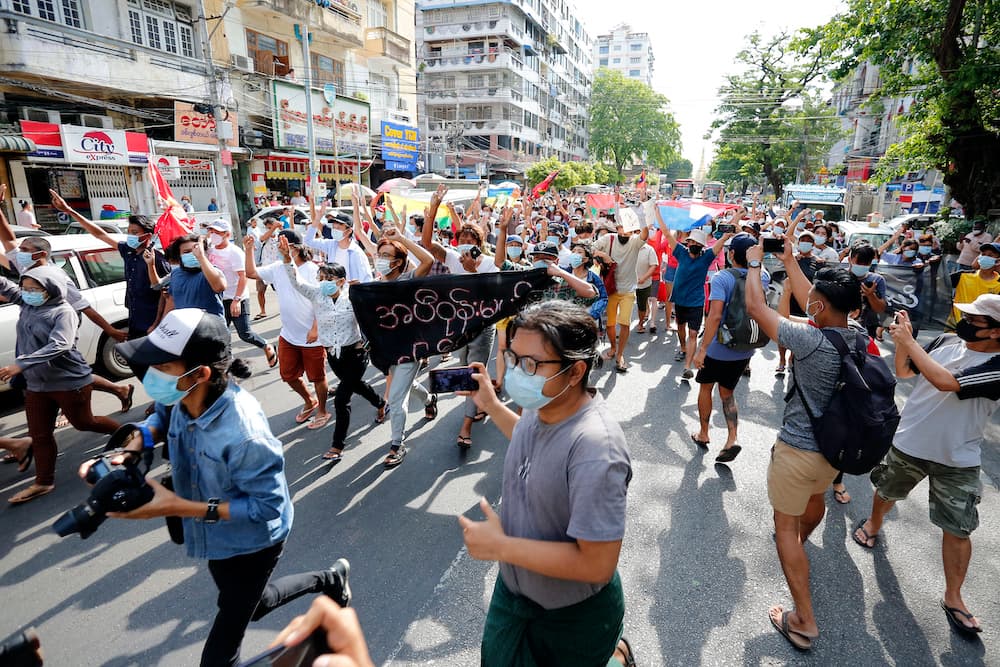 Myanmar journalists take cover during a flash mob protest against the military coup near Sule Pagoda in central Yangon, Myanmar on May 6, 2021. Photo by Myat Thu Kyaw/NurPhoto